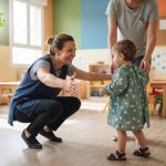 Niña abrazando a su profesora en escuela infantil